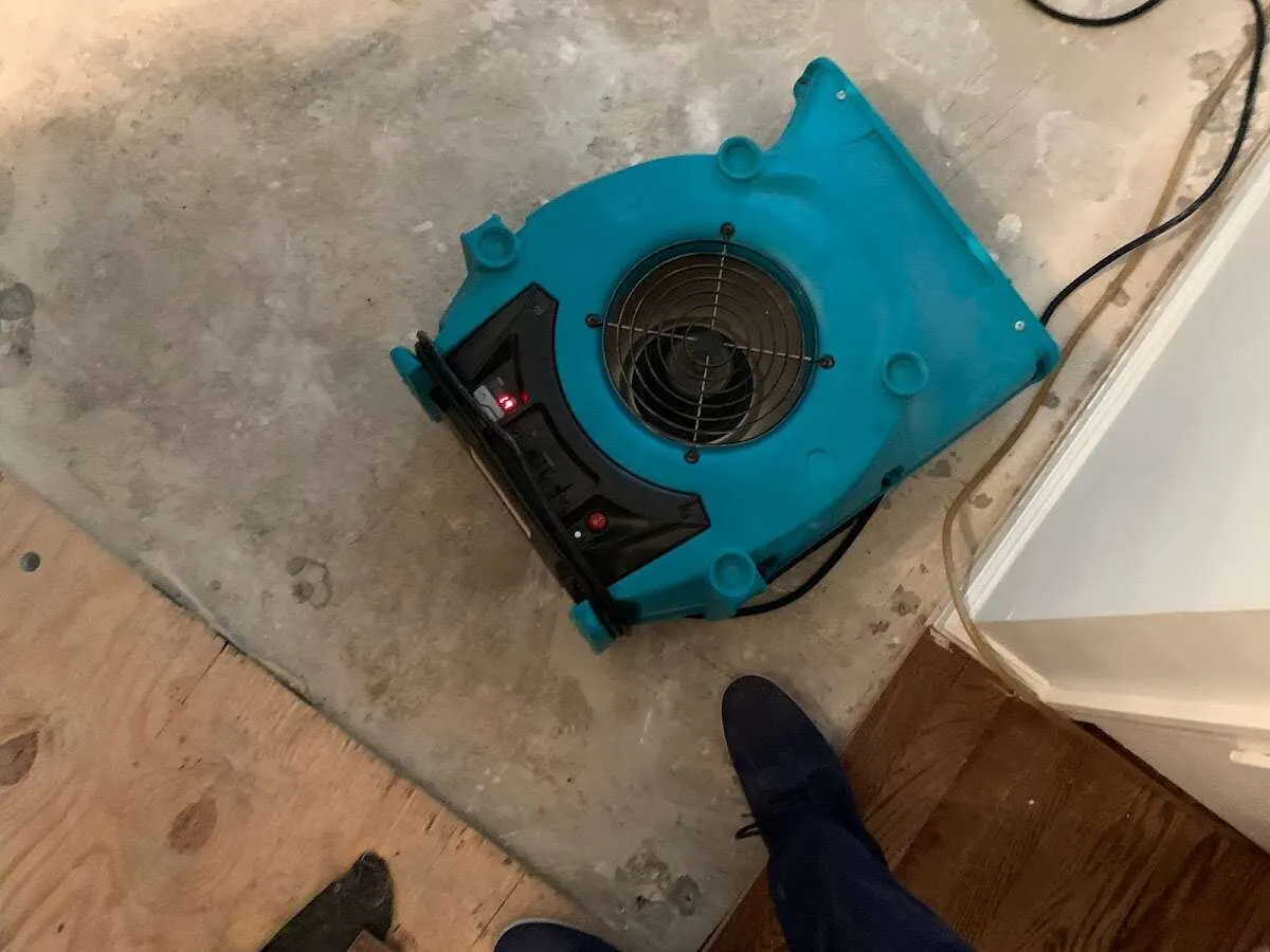 Air mover drying subfloor during Commercial Water Damage Restoration in West Greenwich